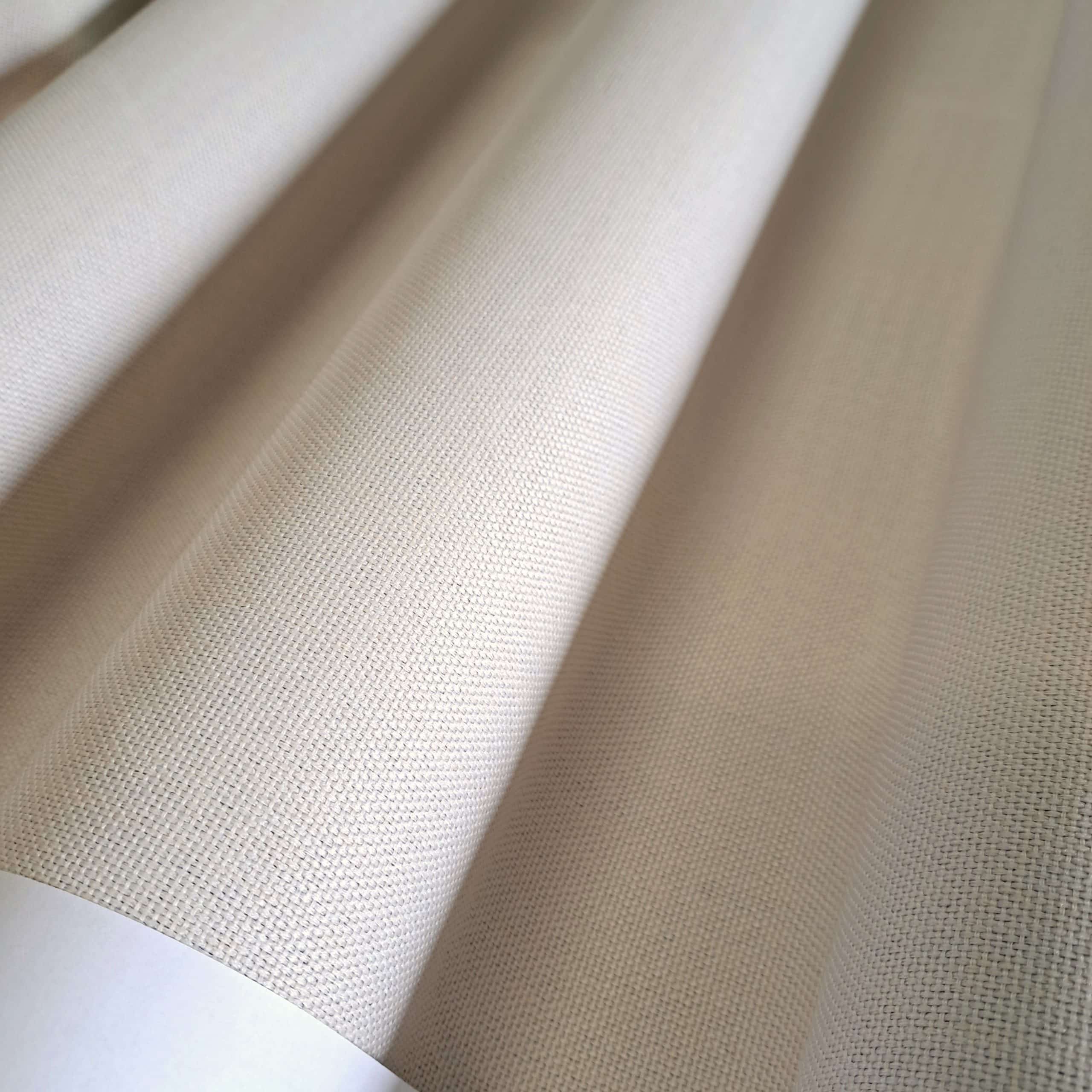 Beżowa tkanina o fakturze zbliżonej do płótna, złożona w równoległe fałdy. Idealna na zasłony lub tapicerkę.