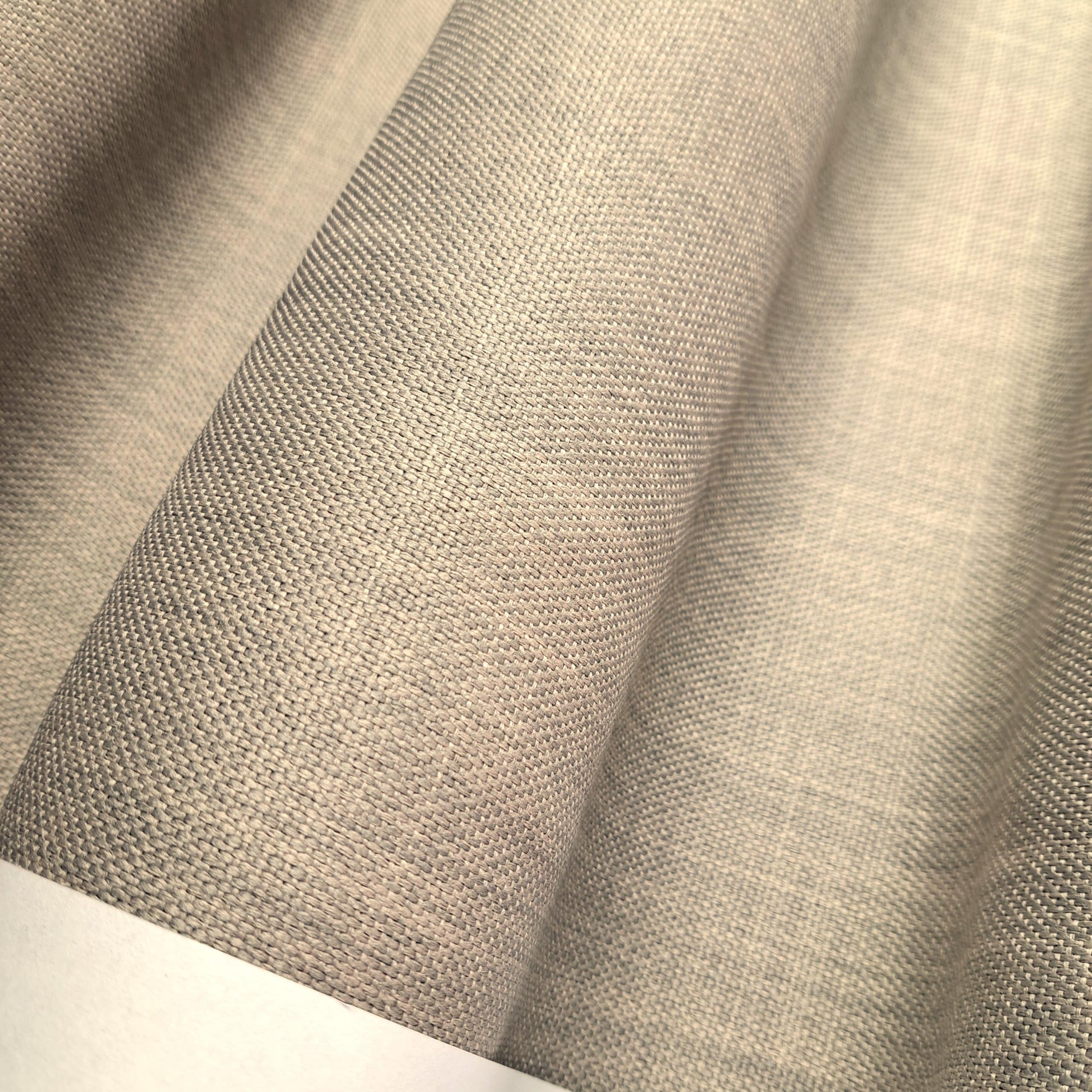 Beżowy materiał o fakturze tkaniny, zbliżenie na wzór i strukturę splotu tekstylnego.