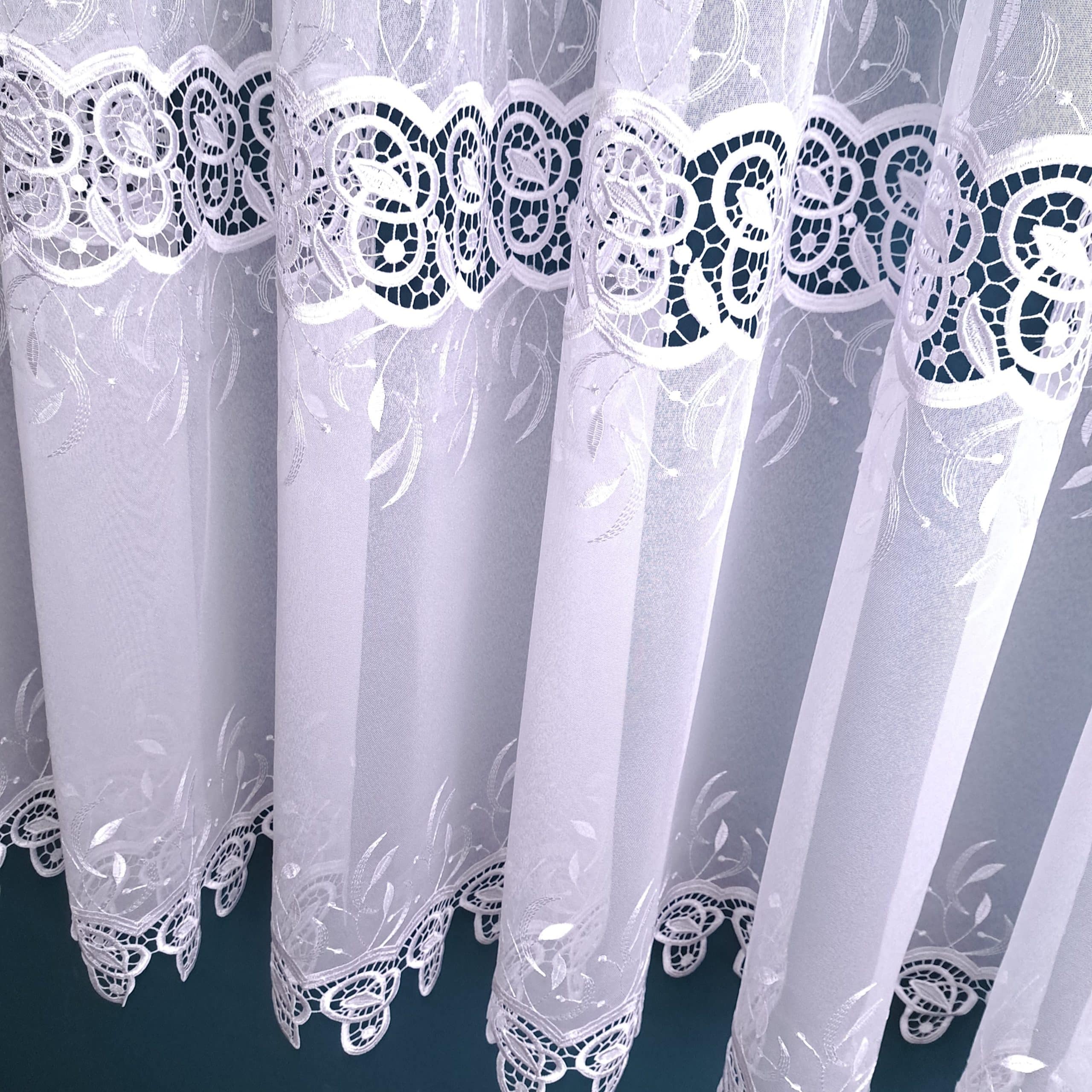 Biały firanka z eleganckim wzorem koronkowym, idealna do okien salonu.