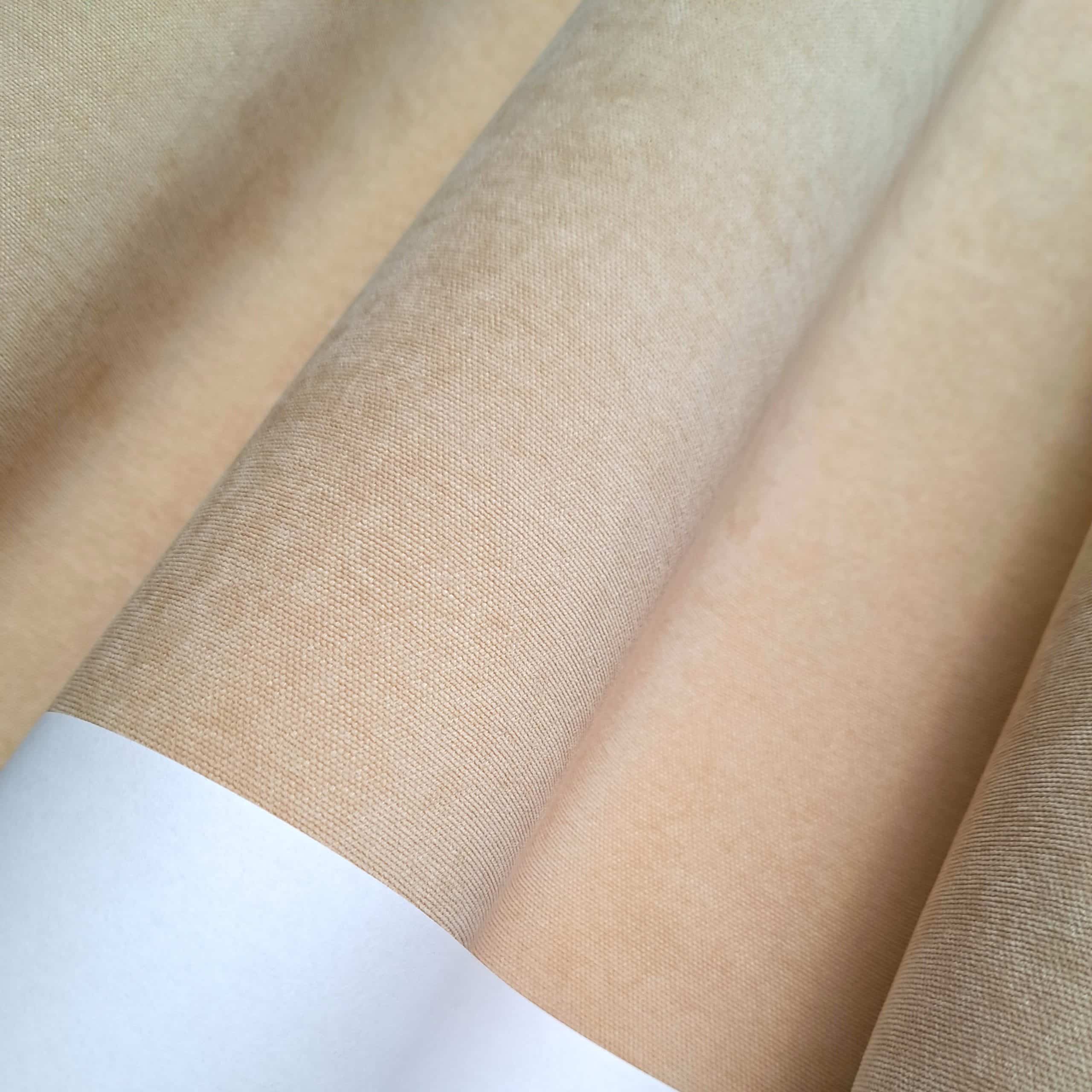 Beżowa rolka papieru ścienego ułożona w wachlarz, z widoczną fakturą materiału.