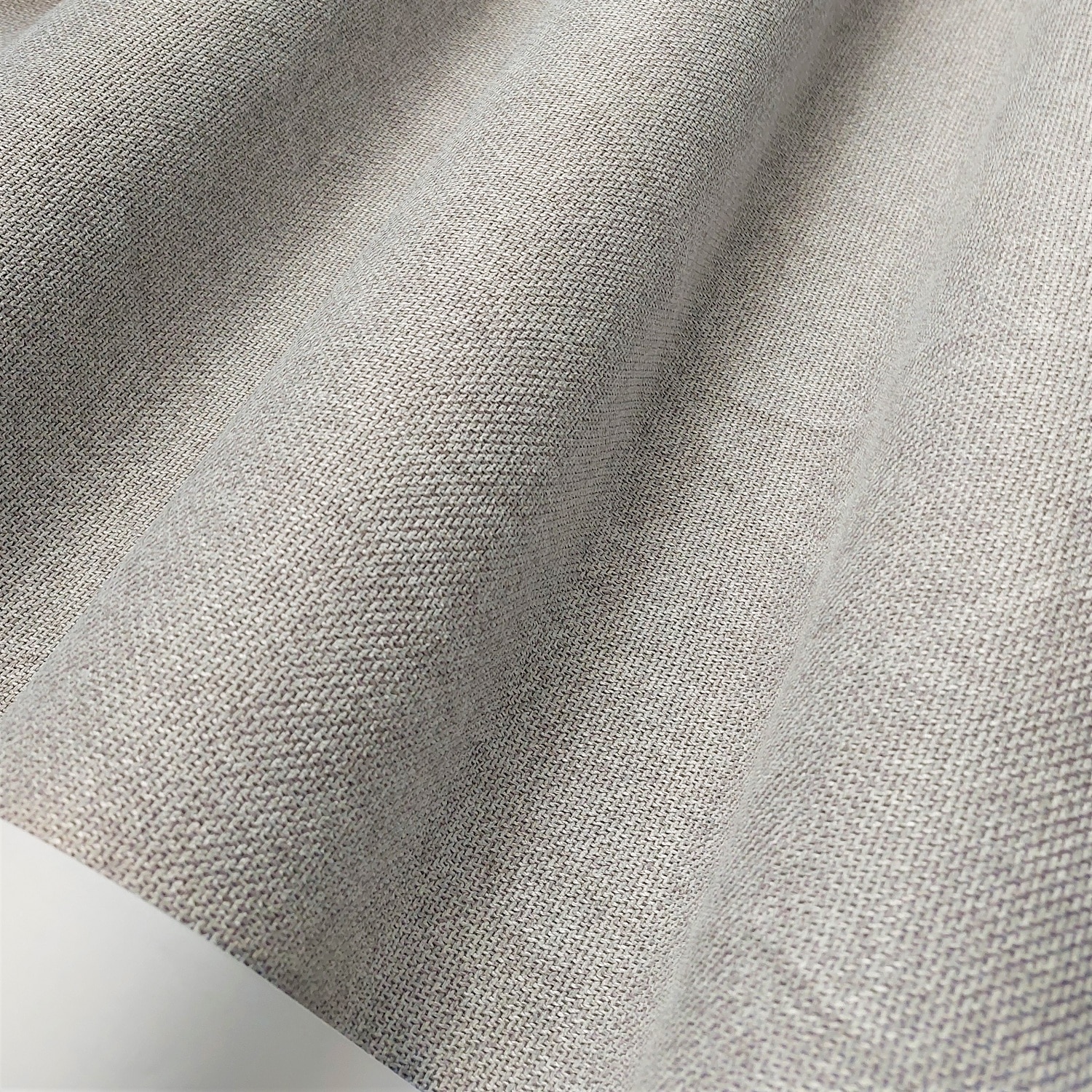 Szara tkanina o fakturze lnianej, z drobnym splotem, falująca w delikatnym świetle. Idealna do dekoracji wnętrz.