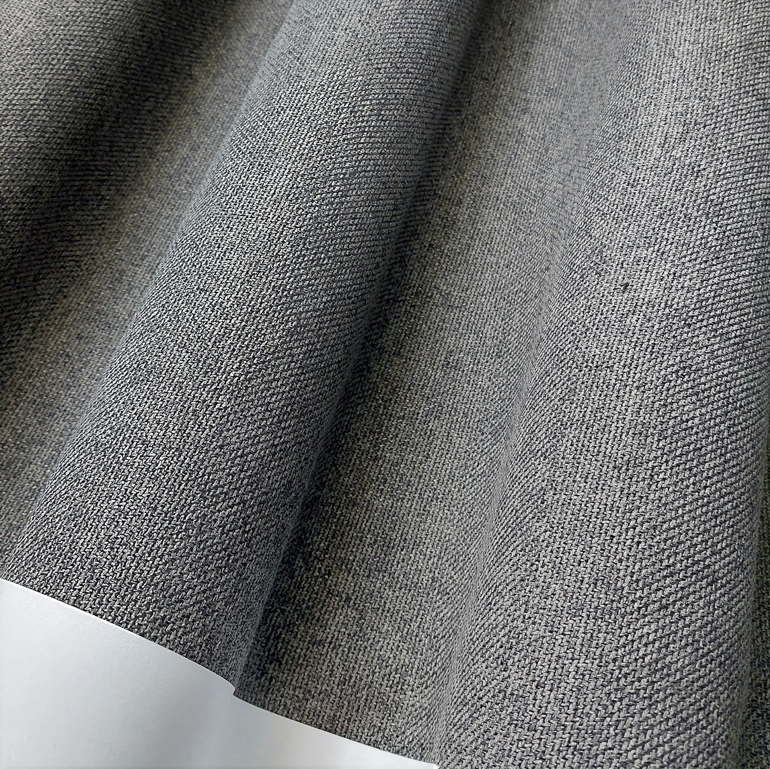 Szara tkanina o fakturze splotu krzyżowego, zbliżenie na wzór i strukturę materiału.