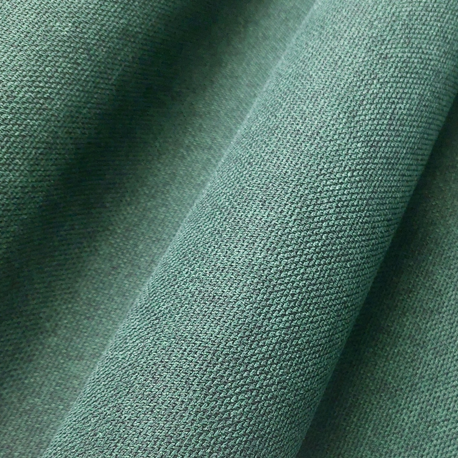 Zielona tkanina bawełniana o drobnej fakturze, zbliżenie materiału, idealna do szycia odzieży.