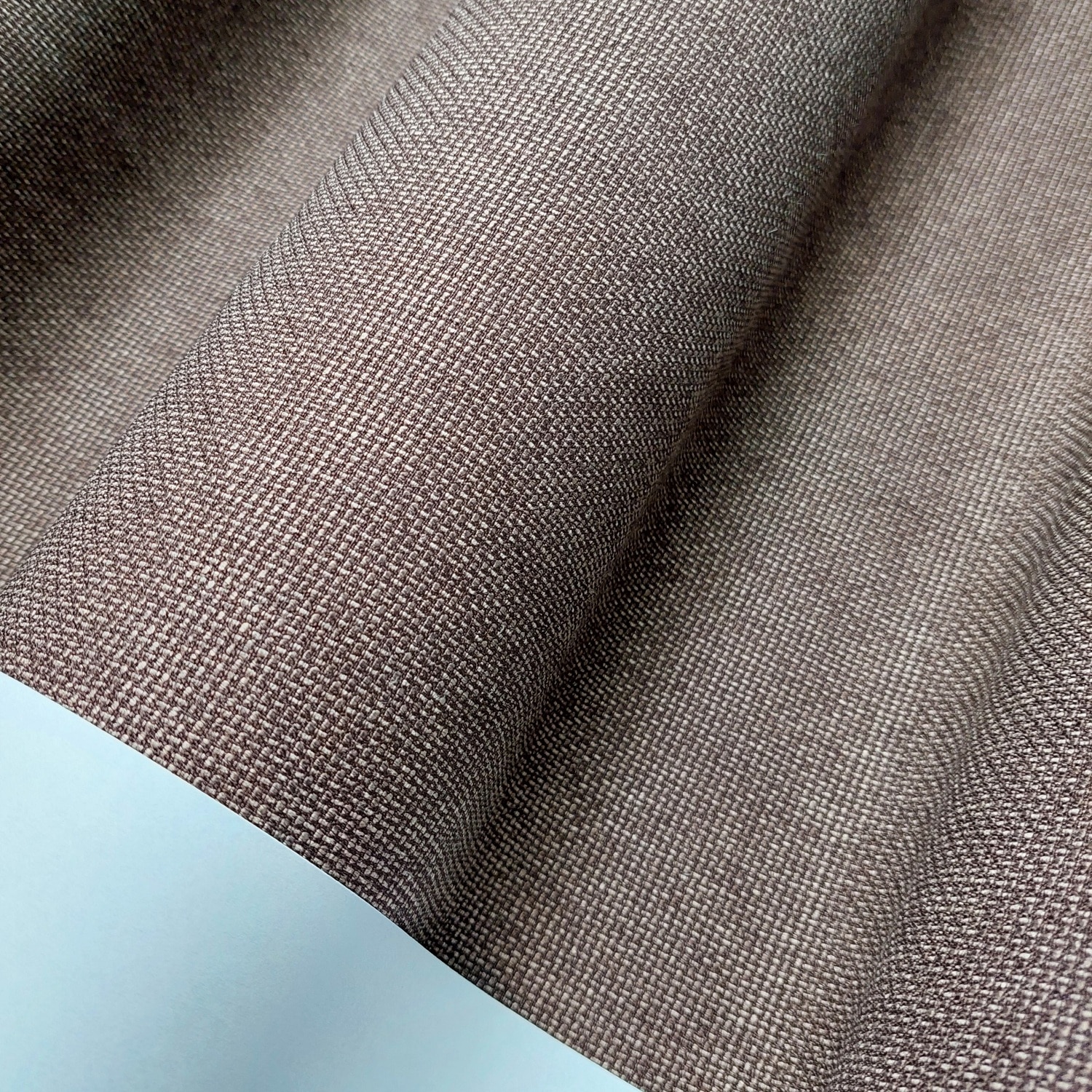 Brązowy materiał tekstylny o wyraźnej strukturze tkanej, widziany z bliska.