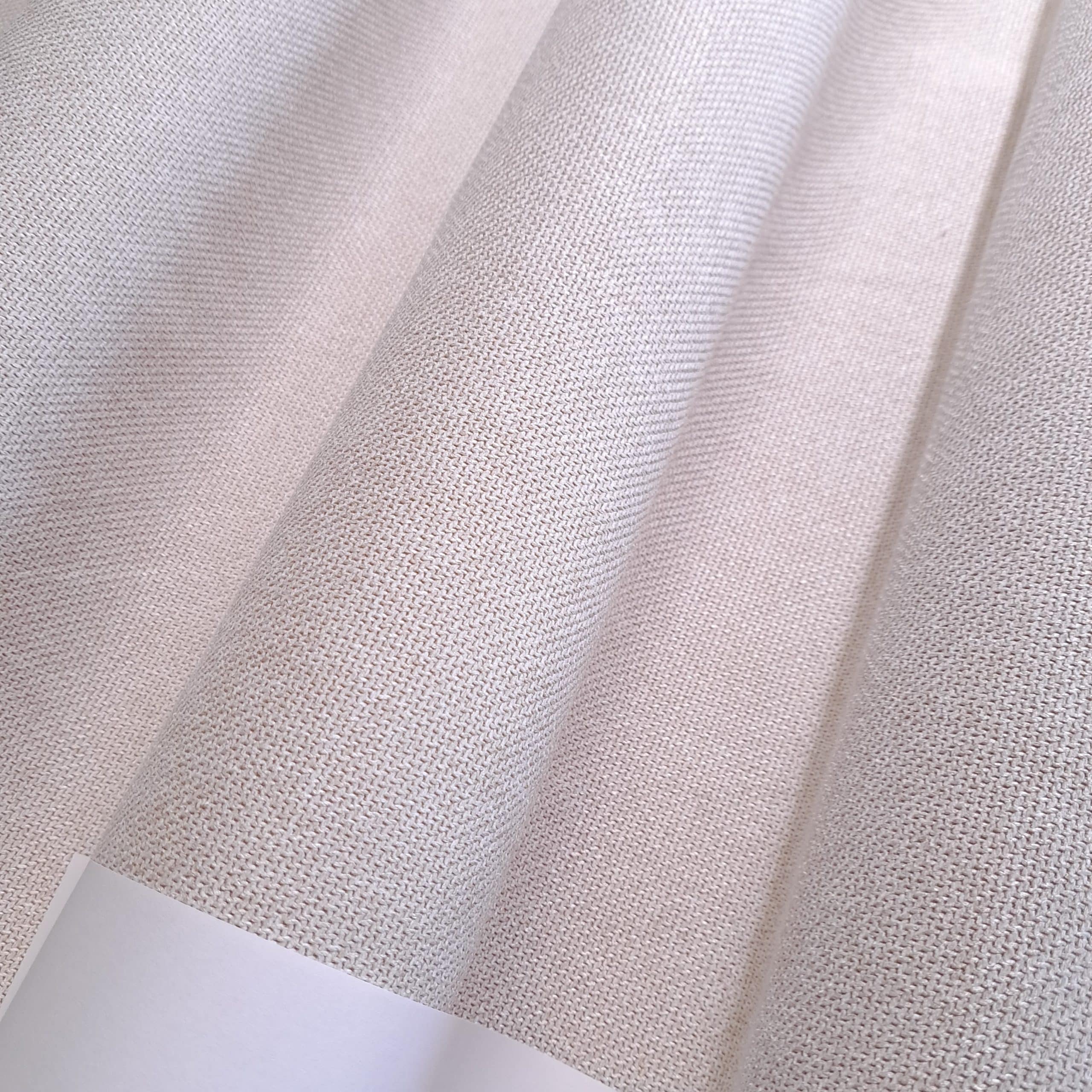 Beżowa tkanina o gęstym splocie, widok z bliska, pionowe fałdy.